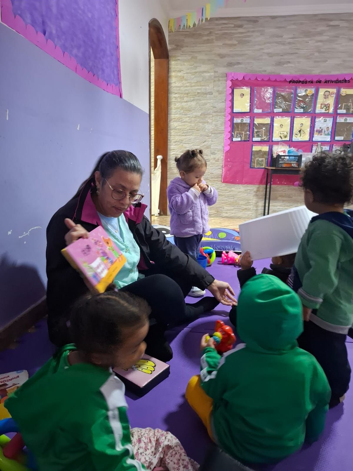 Educadora apresentando livros para o berçário