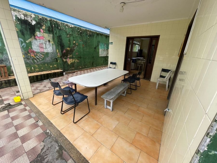 Área de convivência externa com mesa, cadeiras e banco