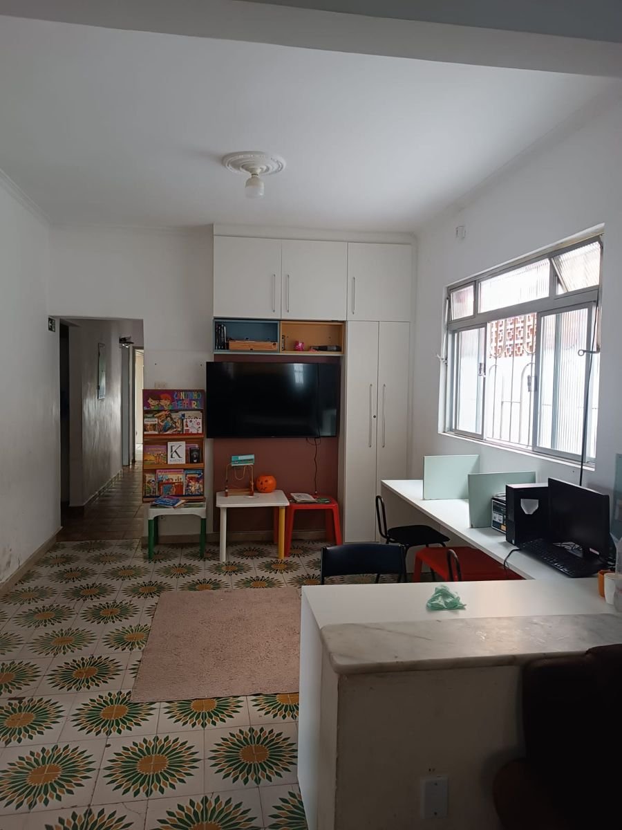 Espaço com cantinho de leitura, televisão e estações de trabalho